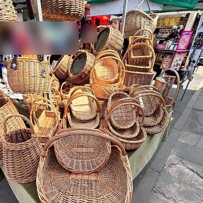 Willow trugs and round baskets piled on the market stall